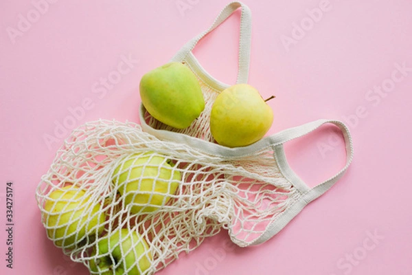 Fototapeta Zero waste shopping, plastic free. Apples in reusable tote bag on pink background flat lay. Shopping groceries online. Order fresh organic food and get them delivered safe. Stay home