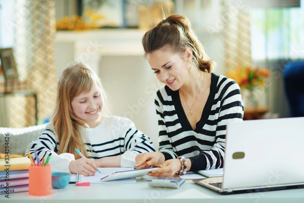 Fototapeta mother at modern home in sunny day working and helping child