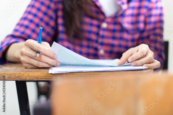 Fototapeta soft focus.high school,university student study.hands writing paper answer sheet.sitting lecture chair taking final exam attending in examination classroom.concept scholarship for education abroad