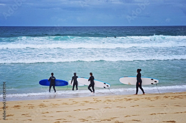 Fototapeta Beginner surfers on the beach. Surfing lesson. Love surfing. Surf school.