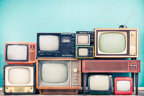 Obraz Retro klasyczne odbiorniki telewizyjne z lat 60., 70. i 80., stary drewniany stojak telewizyjny ze wzmacniaczem frontem miętowo-niebieskim tle ściany. Nadawanie, koncepcja wiadomości. Filtrowane zdjęcie w stylu vintage