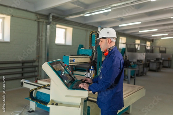 Fototapeta Worker in the Hard Hat Modern Factory CNC machine operator . Successful, Handsome Man in Modern Industrial Environment.Emotions, Copy Space