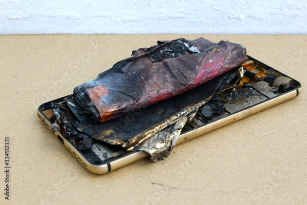 Fototapeta Smartphone battery close up. Explode on brown paper background.