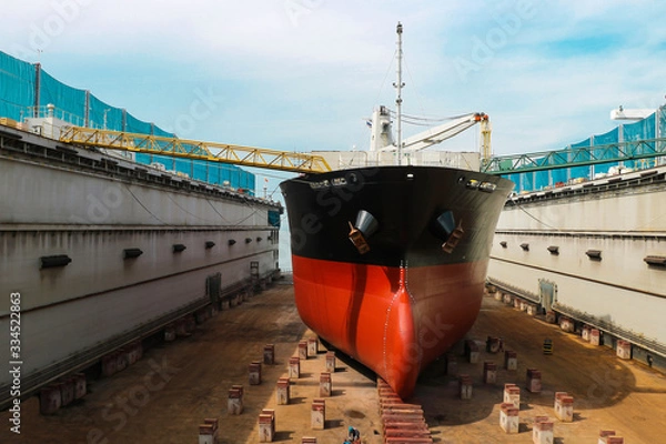 Obraz Shipyard ship repair The bulk carrier general cargo ship in dry dock yard, recondition of hull repairing and repainting, working in dry dock yard.