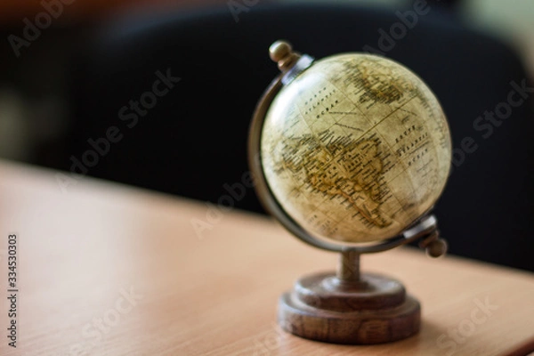 Fototapeta single brown vintage globe on a wooden stand, copy space, blurred background
