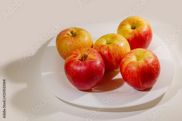 Fototapeta The apples are on a plate on the table.