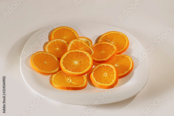 Fototapeta Sliced orange slices lie on a plate.