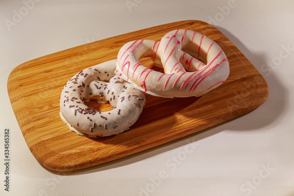 Fototapeta Pretzel cakes are on a wooden Board on the table.