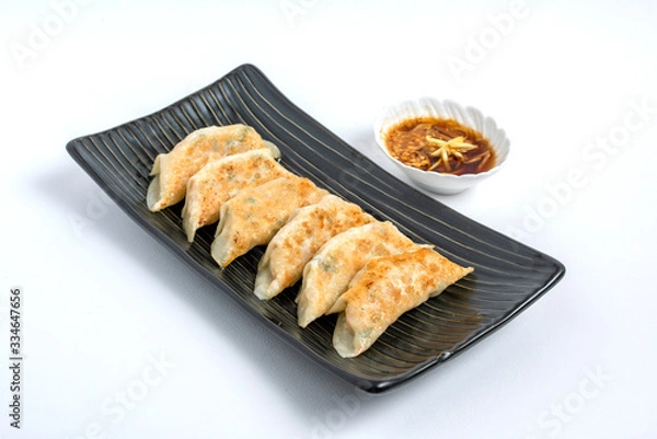 Fototapeta gyoza or dumplings snack with soy sauce on white isolated