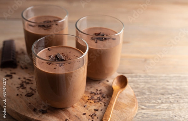 Obraz Homemade chocolate mousse made of dark chocolate,eggs, fresh cream and sugar on a wooden table. Top view.