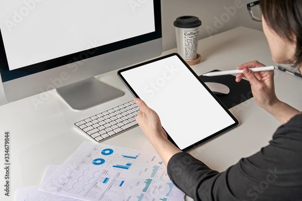 Fototapeta Mockup mobile tablet template with white screen used by a caucasian business woman 