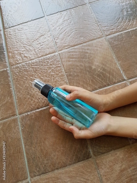 Obraz Closeup of ethyl alcohol in the hands of young boy.  Prevention of Coronavirus Covid-19 concept.