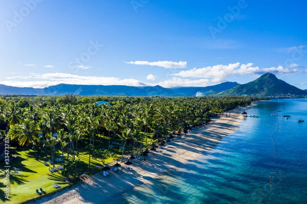 Fototapeta The beach at Flic en Flac with luxury hotels and palm trees, behind the mountain Tourelle du Tamarin, Mauritius, Africa