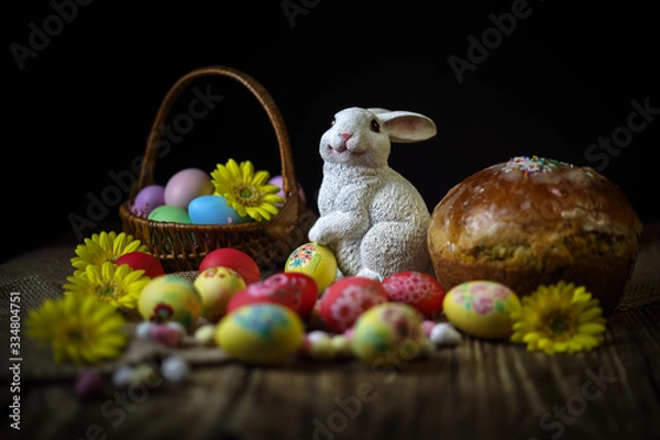 Fototapeta Traditional holiday composition. Hand painting Easter eggs with orthodox sweet bread on a dark wooden table. With rabbit figure. Selective focus. Close-up.