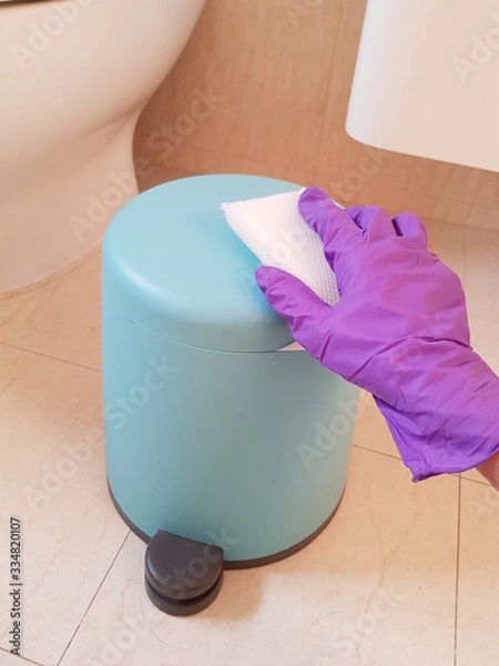 Obraz Closeup of lady wearing glove and using sponge to clean bin in toilet. Hygiene concept. 