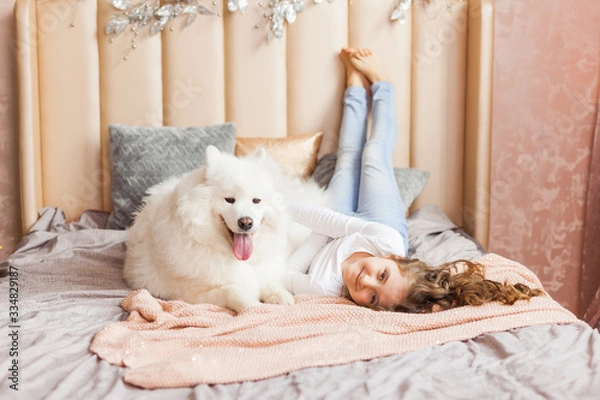 Fototapeta Home portrait of cute child hugging with dog on the sofa