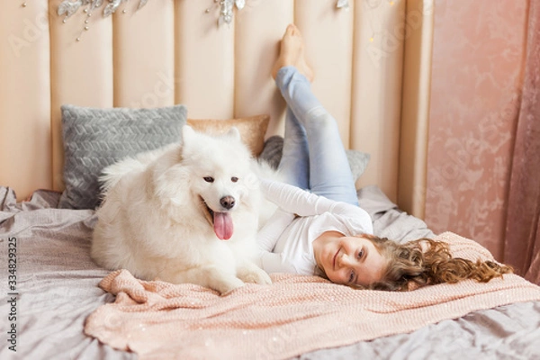 Fototapeta Home portrait of cute child hugging with dog on the sofa
