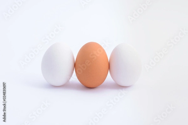 Obraz three upright  eggs(white and brown) on white background