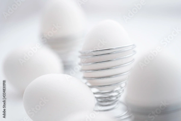 Obraz white eggs in egg holder spiral shaped on white background