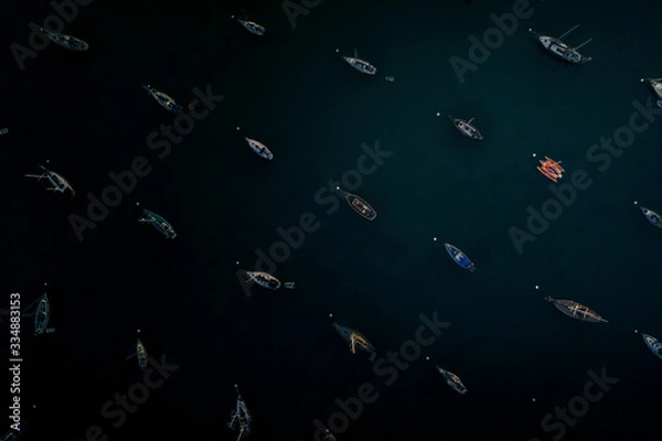 Fototapeta harbor or a bay with a lot of boats and one red boat anchored or moored
