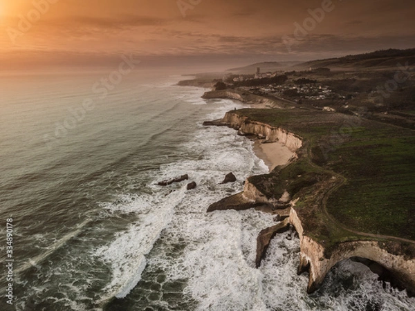 Fototapeta take a drive and see the coast and sunset with waves and beach