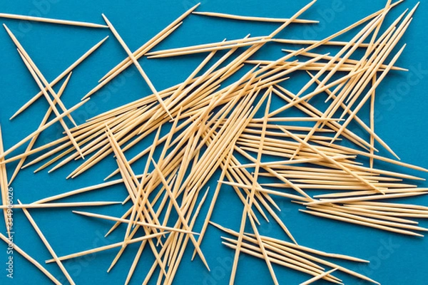 Fototapeta Lots of wooden toothpicks on a blue background. The concept of order and chaos.