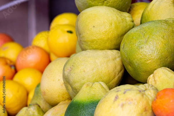 Obraz Pile of pomelo fruits at food market, selective focus on foreground on pomelo fruit, blurred citrus fruit on background