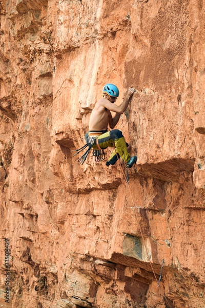 Fototapeta Escalador sorteando una caída grande en roca
