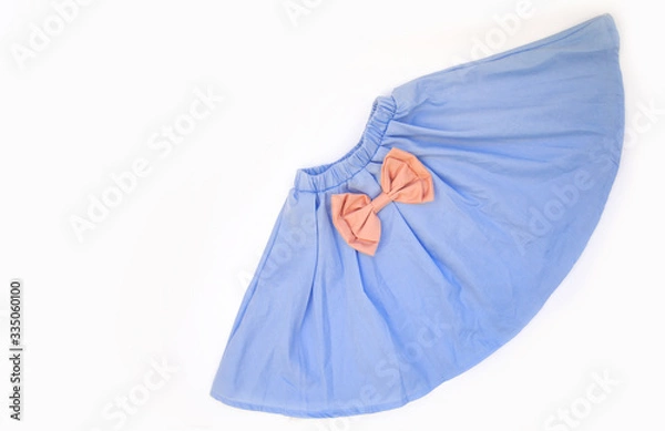 Fototapeta Fluffy blue children's skirt with a pink bow, isolated under the white background. View from above