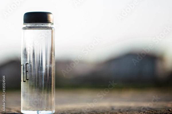 Obraz Water bottle. Mug. Water bottle lying on concrete and behind it a blurred background. Coffee. It's time to drink a donut. Water.