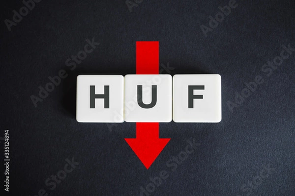 Fototapeta Hungarian forint alphabetic currency ISO code (HUF) and down red arrow on black background. Economy of Hungary.