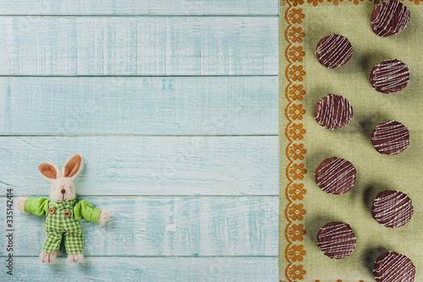 Fototapeta Top view of brazilian home made honey cookies chocolate covered on wooden background with stuffed rabbit and copy space - Pães de mel