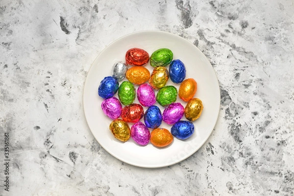 Fototapeta Plate with sweet chocolate eggs on light background