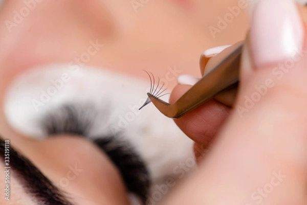 Fototapeta Eyelash Extension Procedure. Woman Eye with Long Eyelashes. Lashes, close up, macro, selective focus.