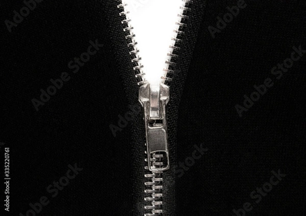 Obraz Open zipper or clothes lock on black fabric