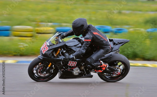 Fototapeta Motorcycle practice leaning into a fast corner on track