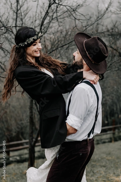 Fototapeta gorgeous bride and stylish groom, boho wedding couple, luxury ceremony at mountains with amazing view, space for text