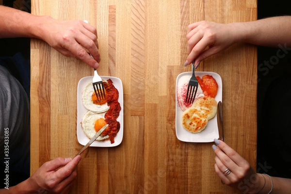 Fototapeta couple have breakfast on wood table cheese pancake with sour cream and fried egg with bacon top view