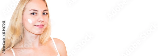 Fototapeta Beautiful blonde woman touching her perfect soft face skin with fingers, using face cream, cosmetology procedures.Spa, skincare and wellness. Close up, background, copyspace.