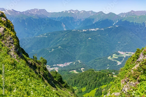 Obraz View from the heights to the Valley with residential houses, surrounded by high mountains. Krasnaya Polyana, Sochi