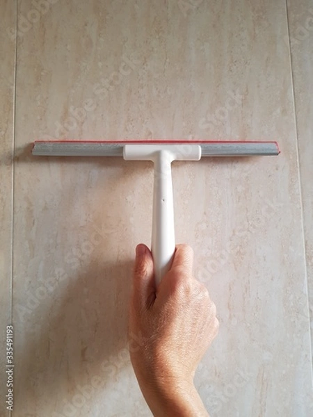 Obraz Closeup of lady using water repellent rubber brush to clean tile wall copy space.
Housewares concept.