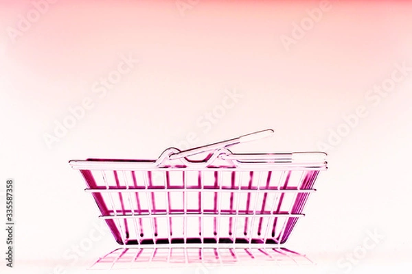 Obraz metal shopping basket on a pink background with reflection