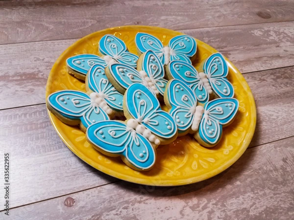 Fototapeta Abstract butterfly cookies on a yellow plate and background