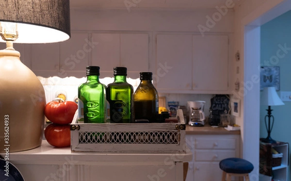 Fototapeta Glass bottles of healthy olive oil aligned on a home shelf in the kitchen