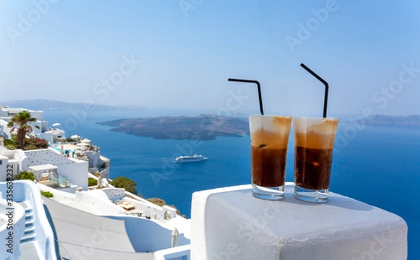 Obraz Two glasses of cold coffee in Santorini island. Traditional Greek Freddo cappuccino and sea view.