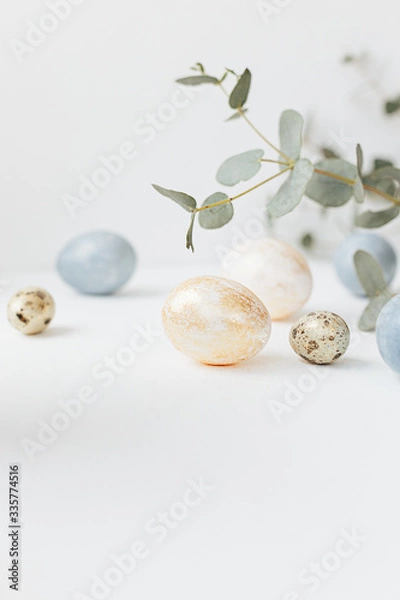 Fototapeta Glazed easter cake kulich decorated with flowers and colored eggs on white textured background. Happy Easter Holidays.