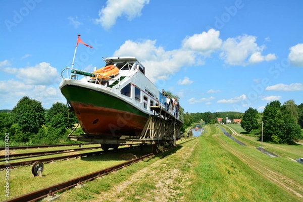Fototapeta Mechanical equipment for transporting boats, boat moored to the shore on the Elblag Canal, Poland