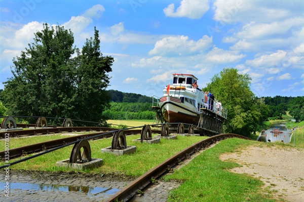 Fototapeta Mechanical equipment for transporting boats, boat moored to the shore on the Elblag Canal, Poland