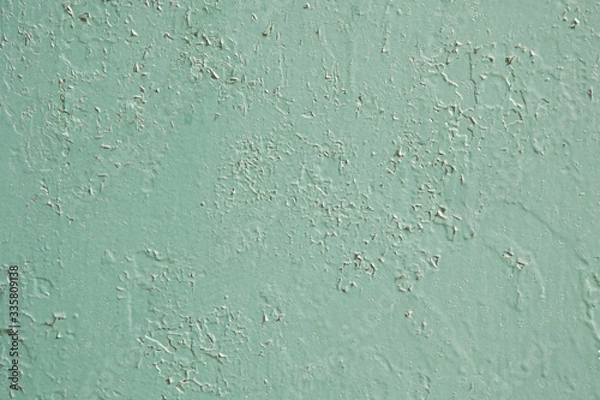 Fototapeta A thick layer of old green-blue paint with a swollen and cracked surface. Background