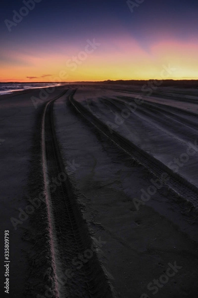 Obraz Samochodem po plaży o zachodzie słońca
